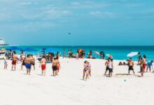 Groups enjoying volleyball and relaxation on sunlit Miami Beach.