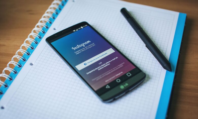 A smartphone displaying Instagram on a notepad with a pen, symbolizing social media and productivity.