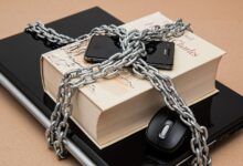 Chain-locked book, phone, and laptop symbolizing digital and intellectual security.