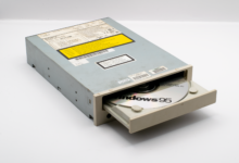 A vintage CD-ROM drive showcasing a Windows 95 disc, reflecting retro technology.