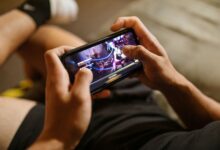 A person playing a mobile video game on a smartphone, focusing on gaming and technology lifestyle.