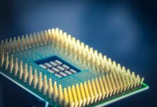 High-resolution macro shot of a computer CPU chip with gold pins against a blue background.