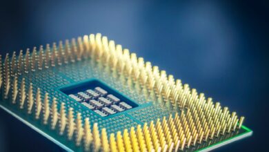 High-resolution macro shot of a computer CPU chip with gold pins against a blue background.
