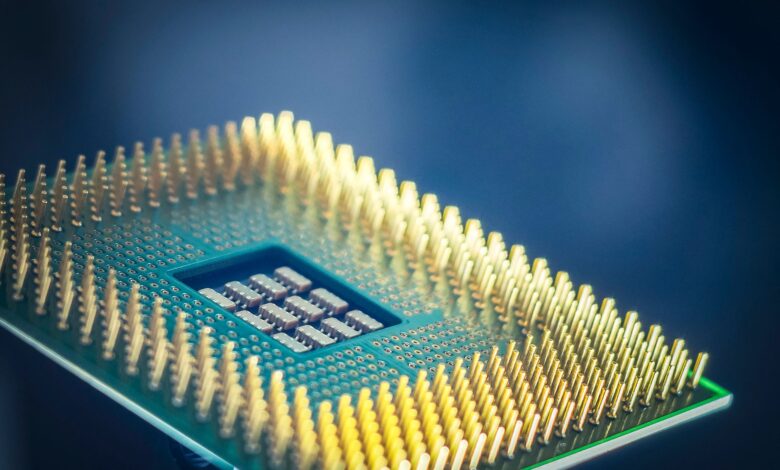 High-resolution macro shot of a computer CPU chip with gold pins against a blue background.