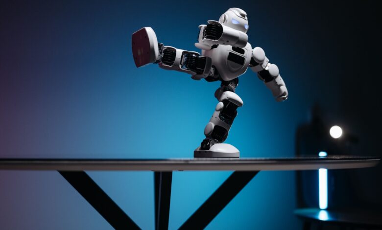 A modern robot toy balancing dynamically on one leg, set against a blue gradient background.