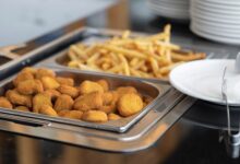 Close-up of crispy nuggets and French fries in a buffet setup, perfect for fast food or catering imagery.