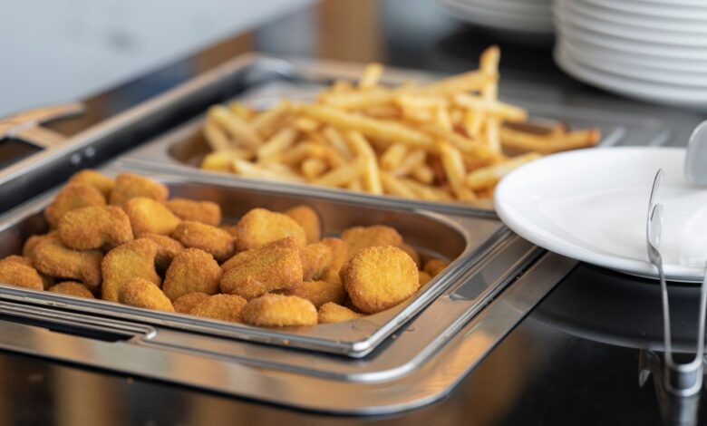 Close-up of crispy nuggets and French fries in a buffet setup, perfect for fast food or catering imagery.