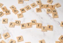 Scrabble tiles spelling Fortnite on a marble surface, ideal for gaming concept art.