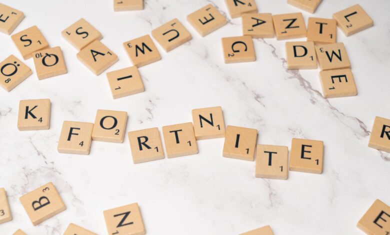 Scrabble tiles spelling Fortnite on a marble surface, ideal for gaming concept art.