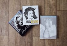 Books featuring Marilyn Monroe, Michael Jackson, and Whitney Houston on a wooden floor.