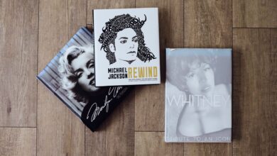 Books featuring Marilyn Monroe, Michael Jackson, and Whitney Houston on a wooden floor.