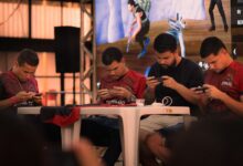 Group of gamers intensely focused during a mobile e-sports tournament indoors.