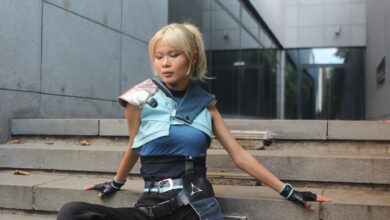 Model poses in futuristic attire on urban steps. Trendy and sleek fashion.