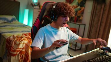 Teenager gaming at home, focused and excited in a modern gaming setup.