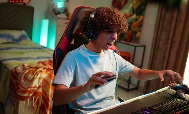Teenager gaming at home, focused and excited in a modern gaming setup.