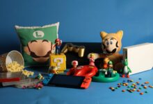 A vibrant assortment of gaming collectibles, including Nintendo figures, consoles, and candy on a blue background.