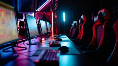 An immersive gaming room with neon lights, computers, and gaming chairs ready for a tournament.