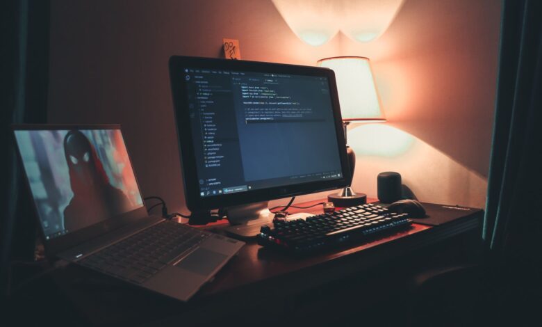 Warmly lit home office with dual screens for coding and programming. Perfect modern workspace for tech enthusiasts.