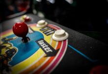 Close-up of a vintage arcade machine control panel with joystick and buttons.
