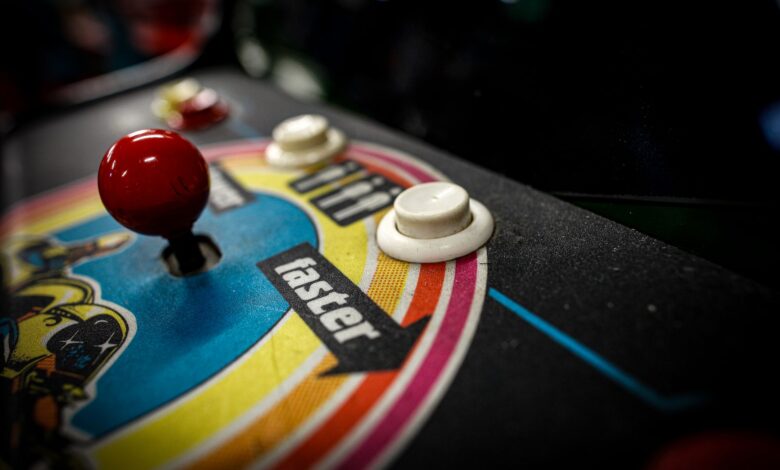 Close-up of a vintage arcade machine control panel with joystick and buttons.