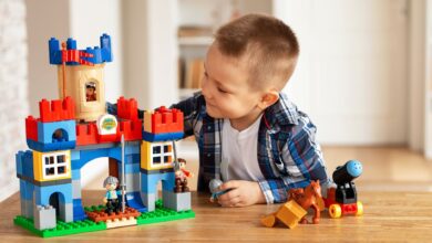 Young boy playing creatively with toy castle and figurines indoors, fostering imagination.