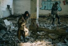 Two people exploring a desolate, abandoned building, embodying a post-apocalyptic theme.
