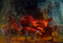 Vibrant dinosaur toy figures enveloped in colored smoke create a dramatic still life composition.