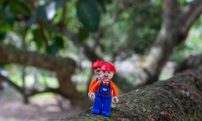Colorful LEGO figure on tree branch, blending creativity with nature.