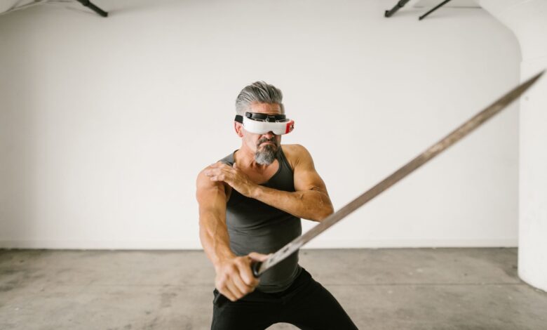 Adult man wearing VR headset practicing sword techniques in empty indoor space.