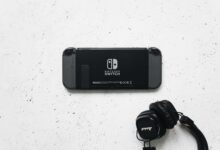 Nintendo Switch and headphones on a minimalist marble background, perfect for gaming content.