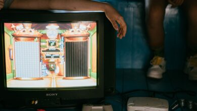 Crop unrecognizable female on modern monitor with video game on screen near ethnic partner