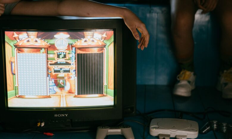 Crop unrecognizable female on modern monitor with video game on screen near ethnic partner