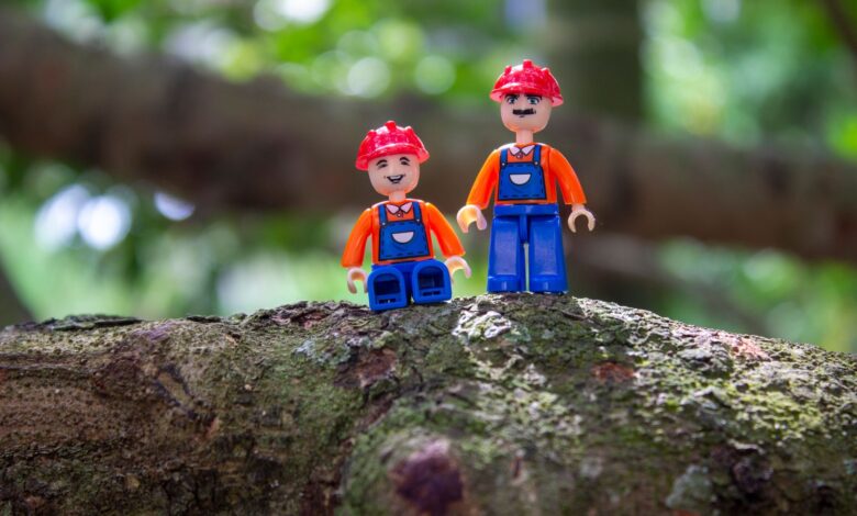 Colorful toy figures with helmets on a tree branch, showcasing creativity and playfulness.