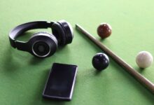 Headphones and smartphone on a snooker table with cue and balls. Perfect lifestyle image.