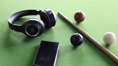 Headphones and smartphone on a snooker table with cue and balls. Perfect lifestyle image.