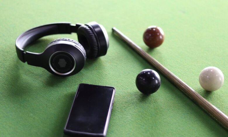 Headphones and smartphone on a snooker table with cue and balls. Perfect lifestyle image.