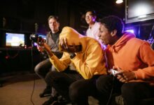 Group of diverse friends enjoying a thrilling video game session indoors. Energetic and fun atmosphere.