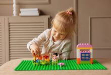 Young girl engaged in building with colorful blocks. Indoor creative activity.