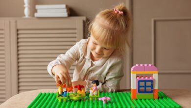 Young girl engaged in building with colorful blocks. Indoor creative activity.