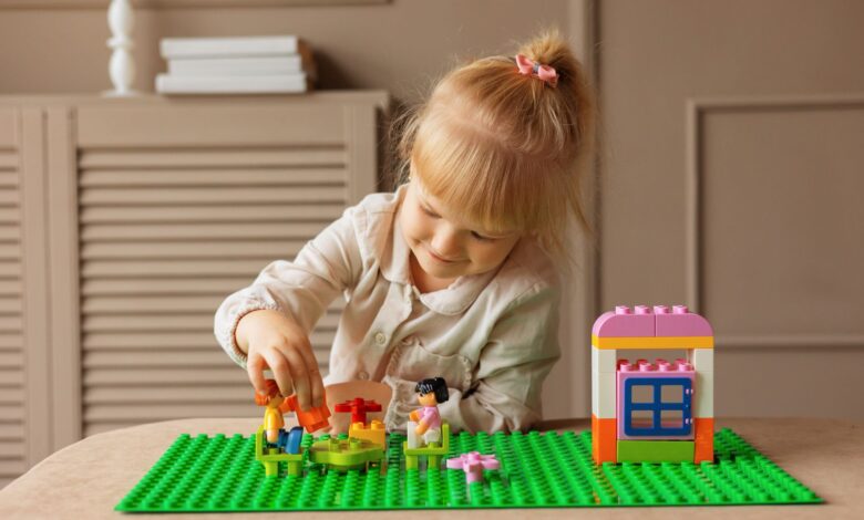 Young girl engaged in building with colorful blocks. Indoor creative activity.