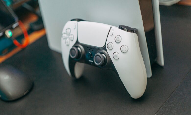 Close-up of a PlayStation 5 controller resting on its console, showcasing modern gaming technology.