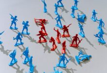 Red and blue toy soldiers on a light surface forming a strategic battle scene.