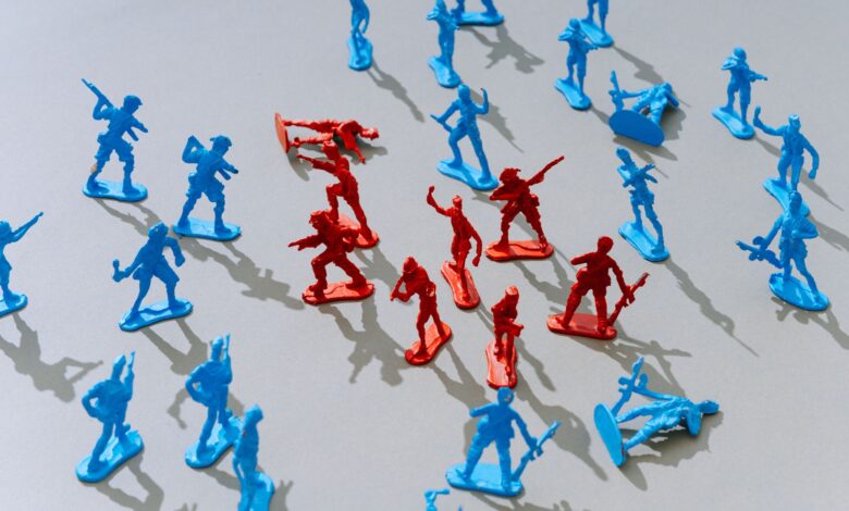 Red and blue toy soldiers on a light surface forming a strategic battle scene.