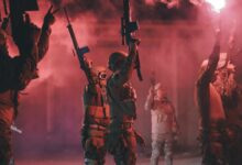 Libyan soldiers holding rifles and red flares in a dynamic military scene.