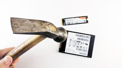 Close-up image of a hammer poised to strike a hard drive and SSD, symbolizing data destruction.