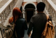 Two students walking through a historic university hallway in Buenos Aires.