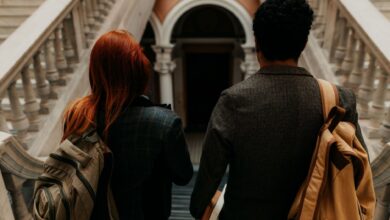 Two students walking through a historic university hallway in Buenos Aires.