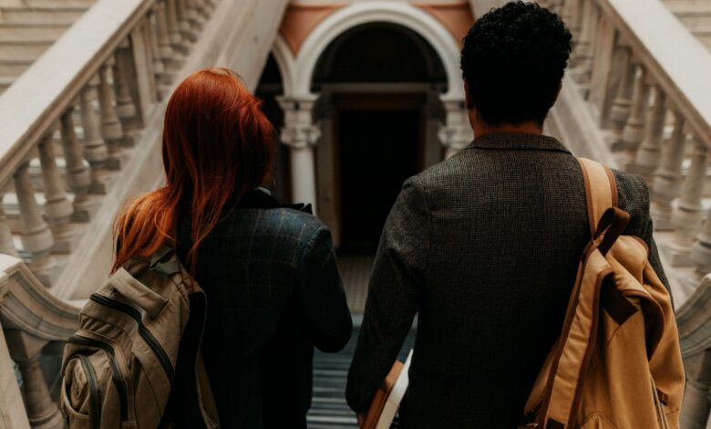 Two students walking through a historic university hallway in Buenos Aires.