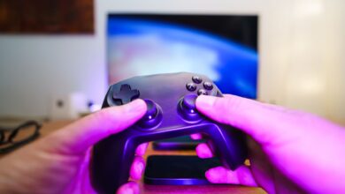 Close-up of hands holding a game controller in front of a TV screen. Perfect for entertainment setups.