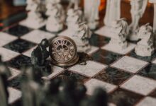 Close-up of a detailed chess set inspired by fantasy themes with a magical vintage clock on the board.